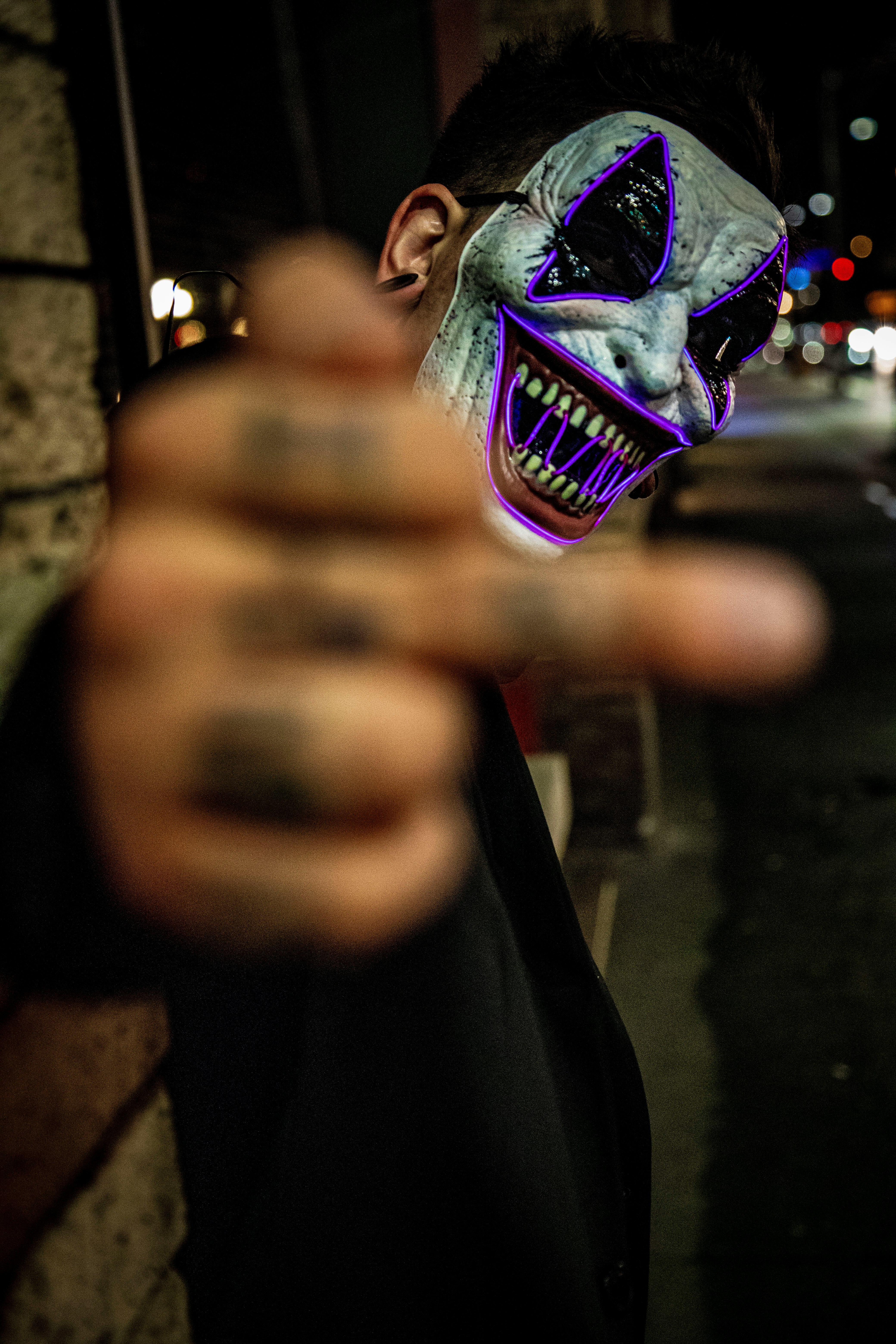 selective focus photo of man wearing white and purple clown face mask